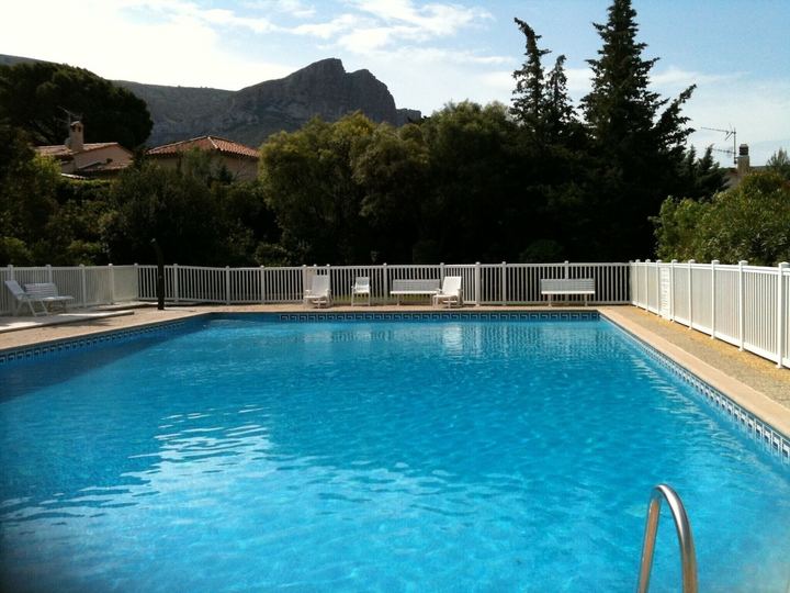 Grande piscine de la résidence de la Villa SOLEDAD, bordée de transats, avec vue sur les reliefs des Calanques